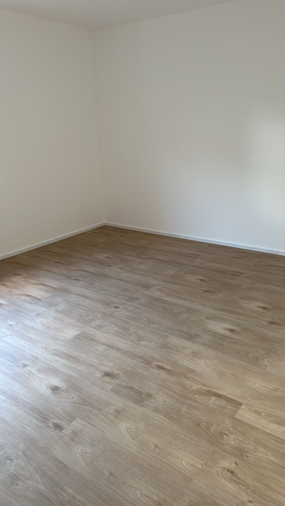Wohnraum mit neu verlegtem Vinylboden in Holzoptik
